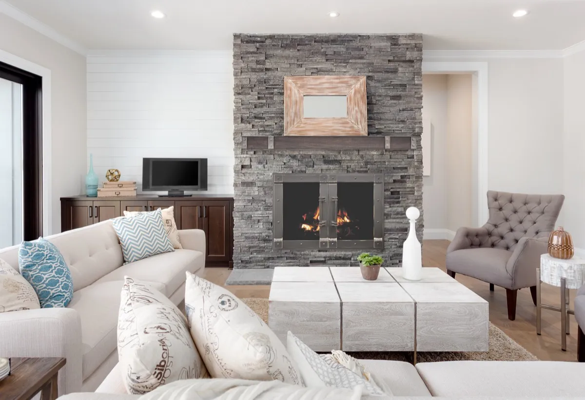 Living room with stacked stone fireplace and custom glass doors