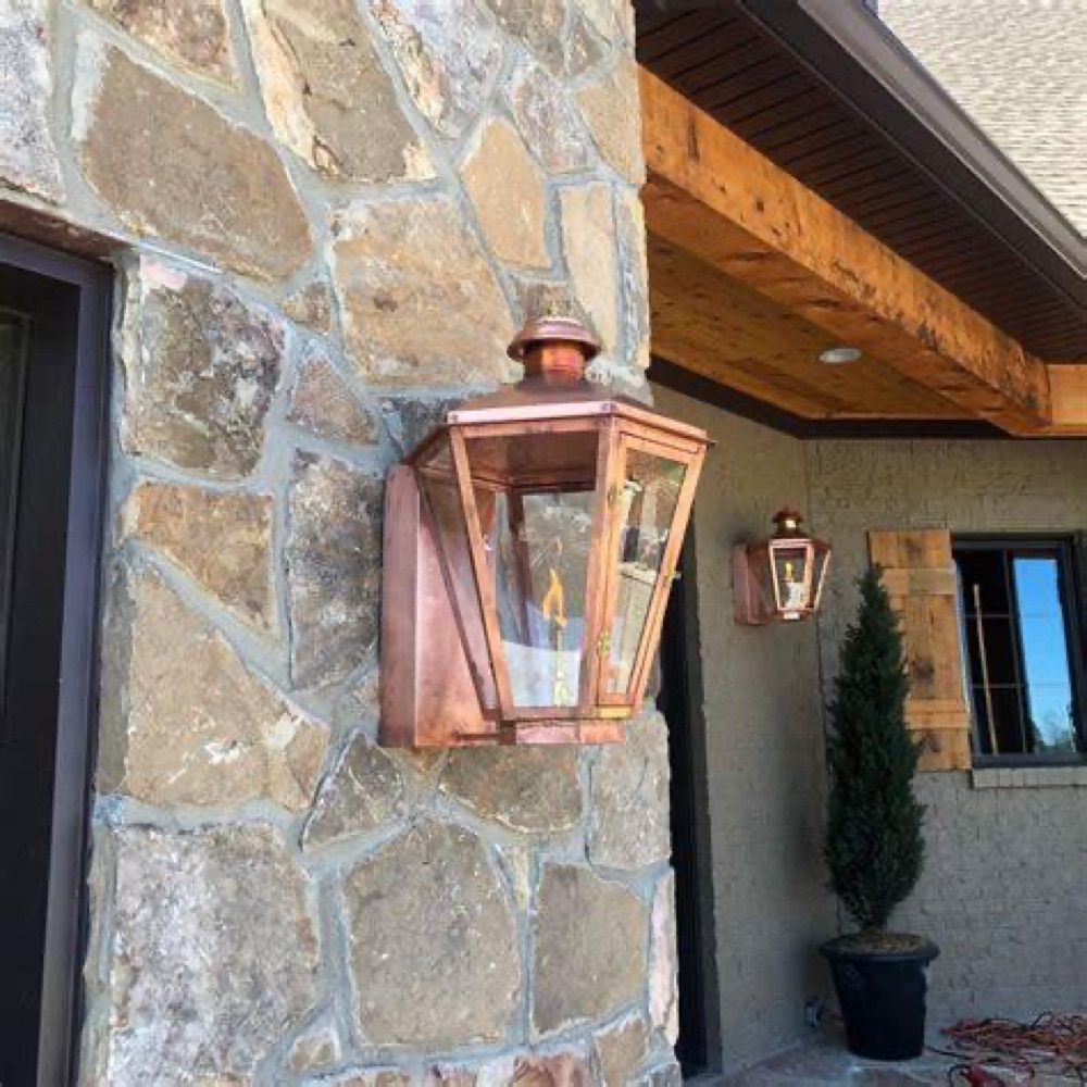 Legendary Lighting Apollo copper gas lantern on a stone wall