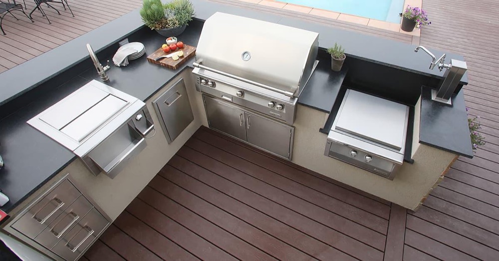 Alfresco outdoor refrigerator drawers in a stainless kitchen island